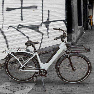 A CYCL Carr-e e-bike for delivery is parked in front of a building.