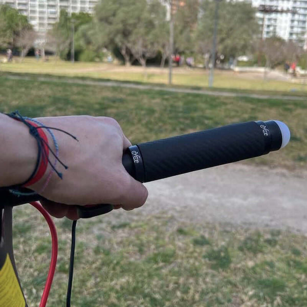 A person holding a bike handlebar with CYCL Heated Handlebar Grips attached to it.