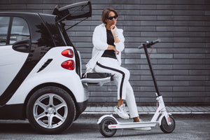 young woman sitting car with electric scooter
