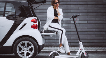 young woman sitting car with electric scooter