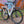 Laden Sie das Bild in den Galerie-Viewer, A white CYCL Carr-e e-bike parked in front of a colorful wall.
