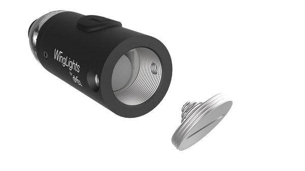 A small black WingLights nExt device with a button on it.